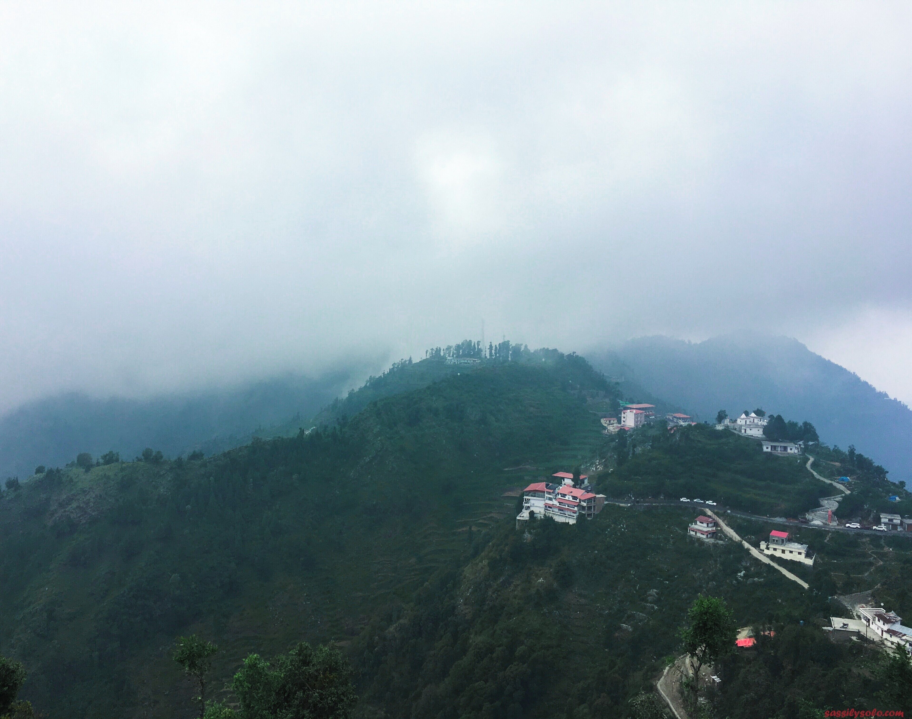 A mountainous landscape with several buildings on the slopes.