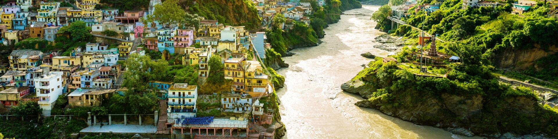 Confluence of two rivers Alaknanda and Bhagirathi give rise to the holy river of Ganga / Ganges at one of the five Prayags called Dev Prayag. Lush greenery in monsoons on the mountains. sunrise. India
