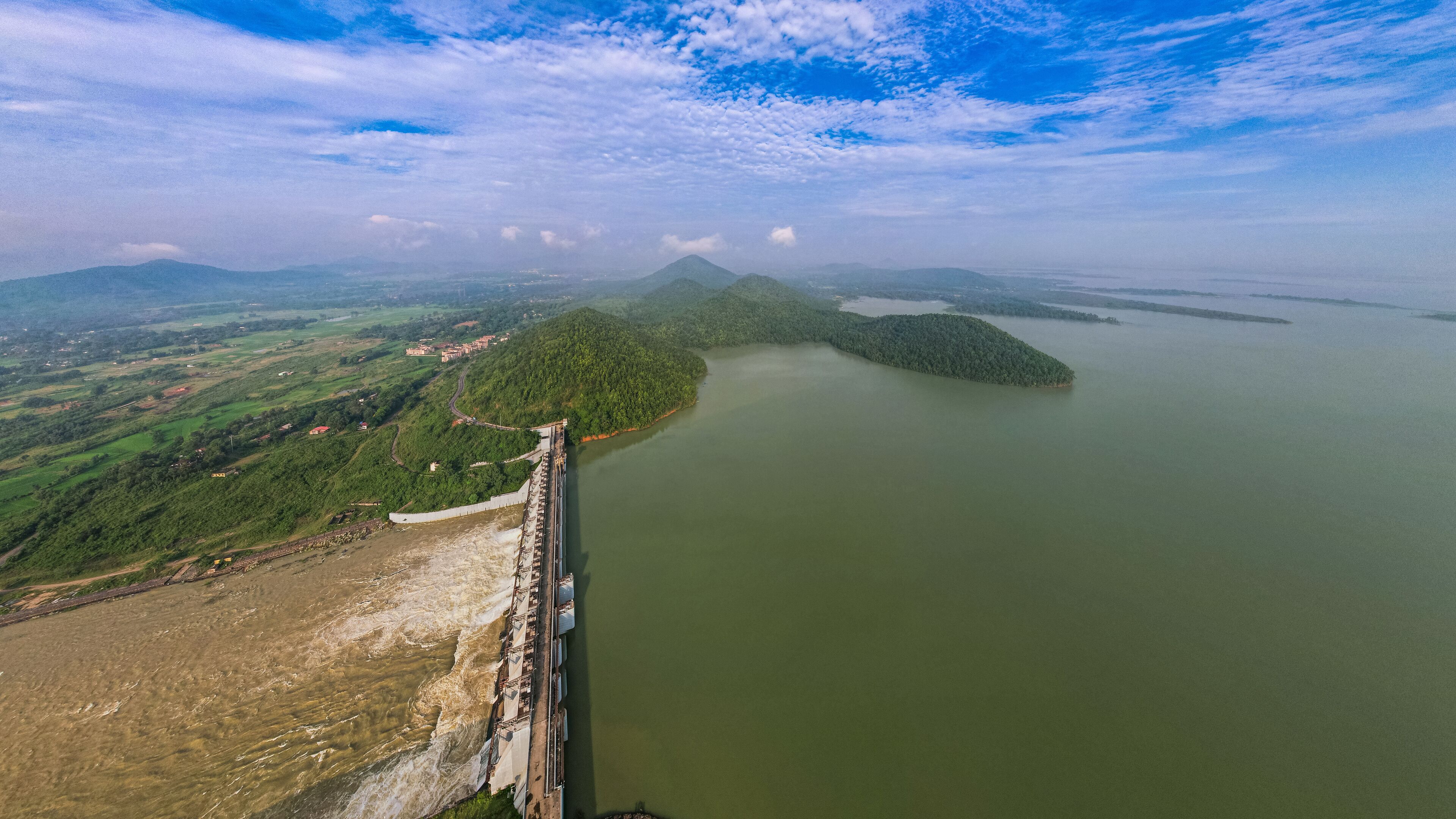 A dam with a reservoir, a bridge, and a mountainous landscape.