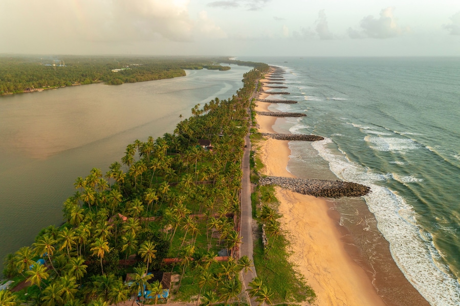 Aerial view of breakwater along a strip of land with Pithrody beach and long coastline along the Arabian Sea, Udupi, Karnataka, India.