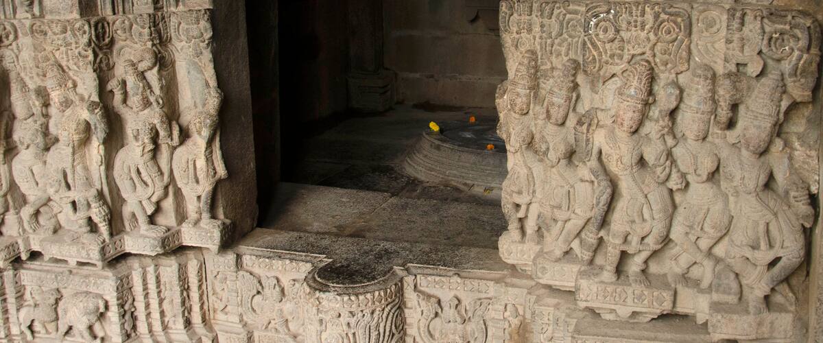 A stone doorway with intricate carvings of figures and patterns.