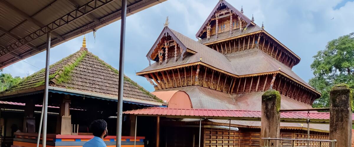 A traditional wooden temple with a multi-tiered roof and a central shrine.