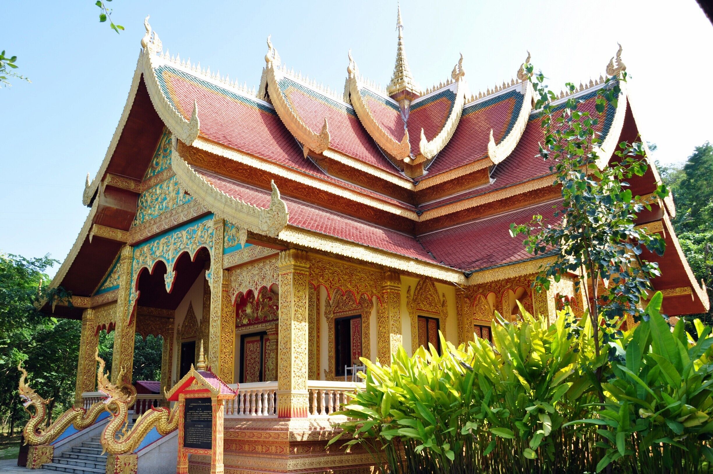A multi-tiered temple with ornate golden decorations and a red roof.