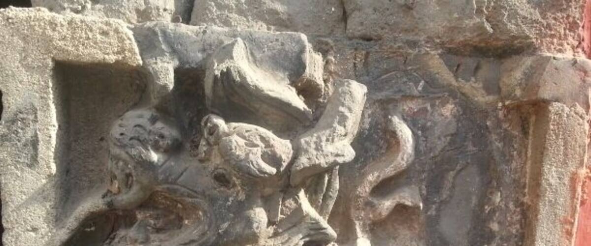 A stone carving of a mythical creature with a lion's body and a dragon's head.