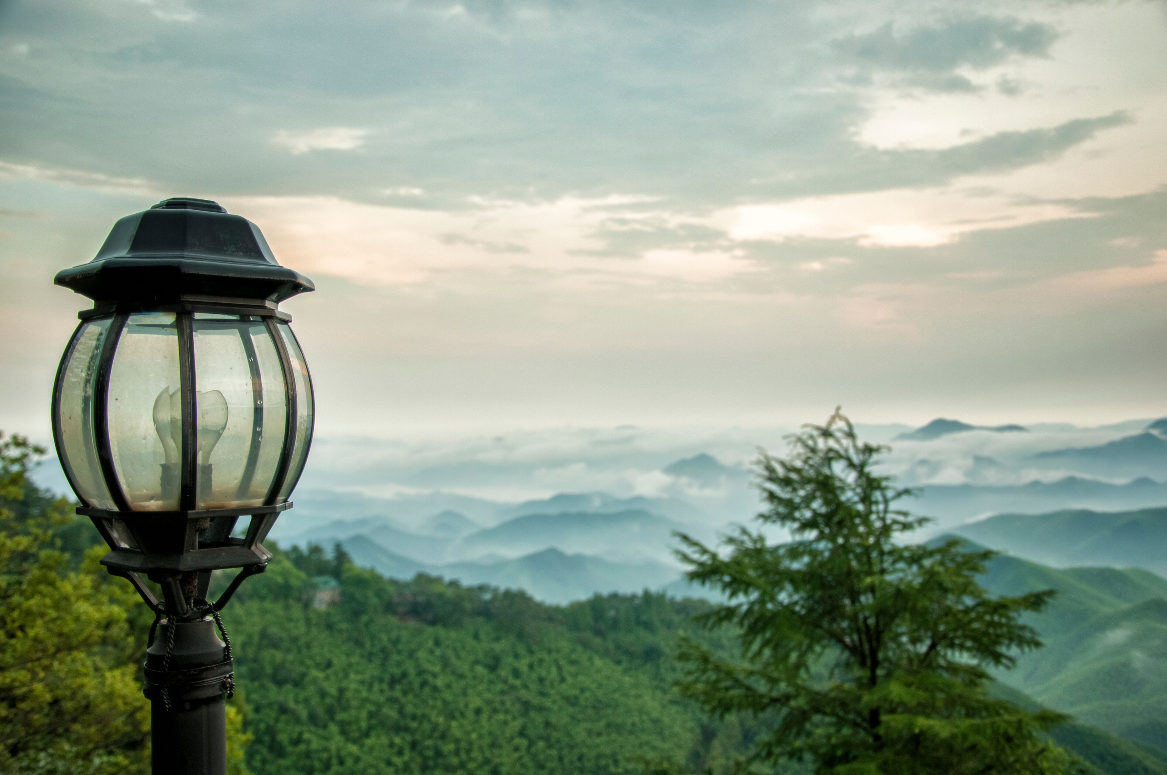 A mountain landscape with a lamppost in the foreground.