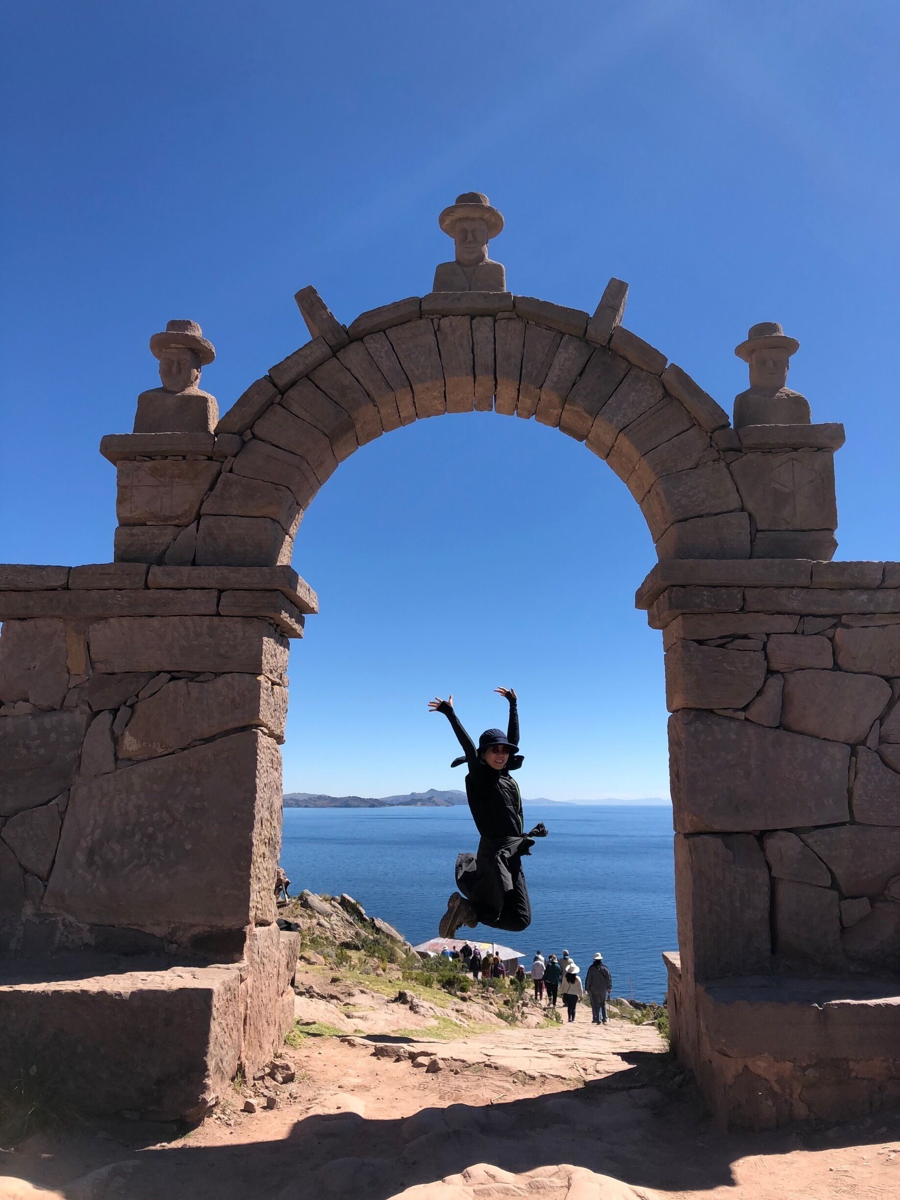 A stone archway with a person jumping through it.