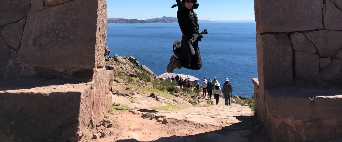 Un arco de piedra con una persona saltando a través de él.