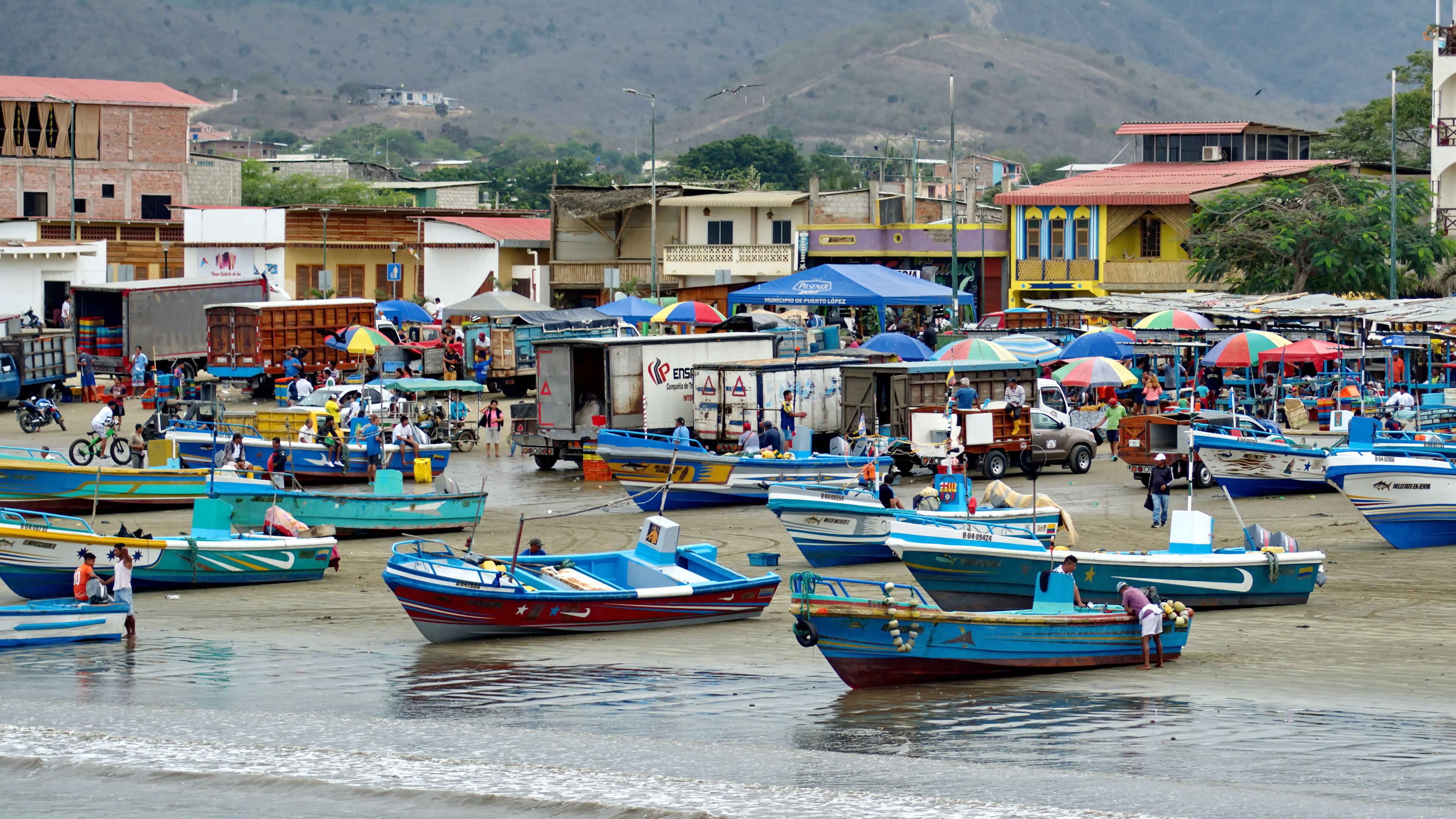 Fishing fleet on the beach, in front of the fish market, at the harbor in Puerto Lopez, Ecuador