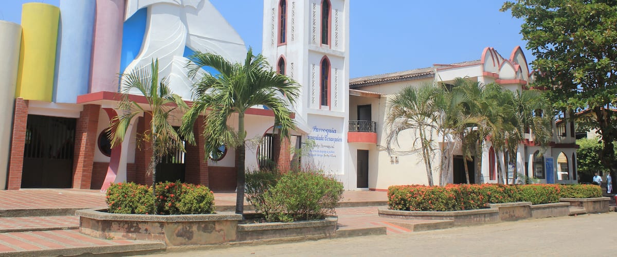 A church with a bell tower and a large statue of a woman.