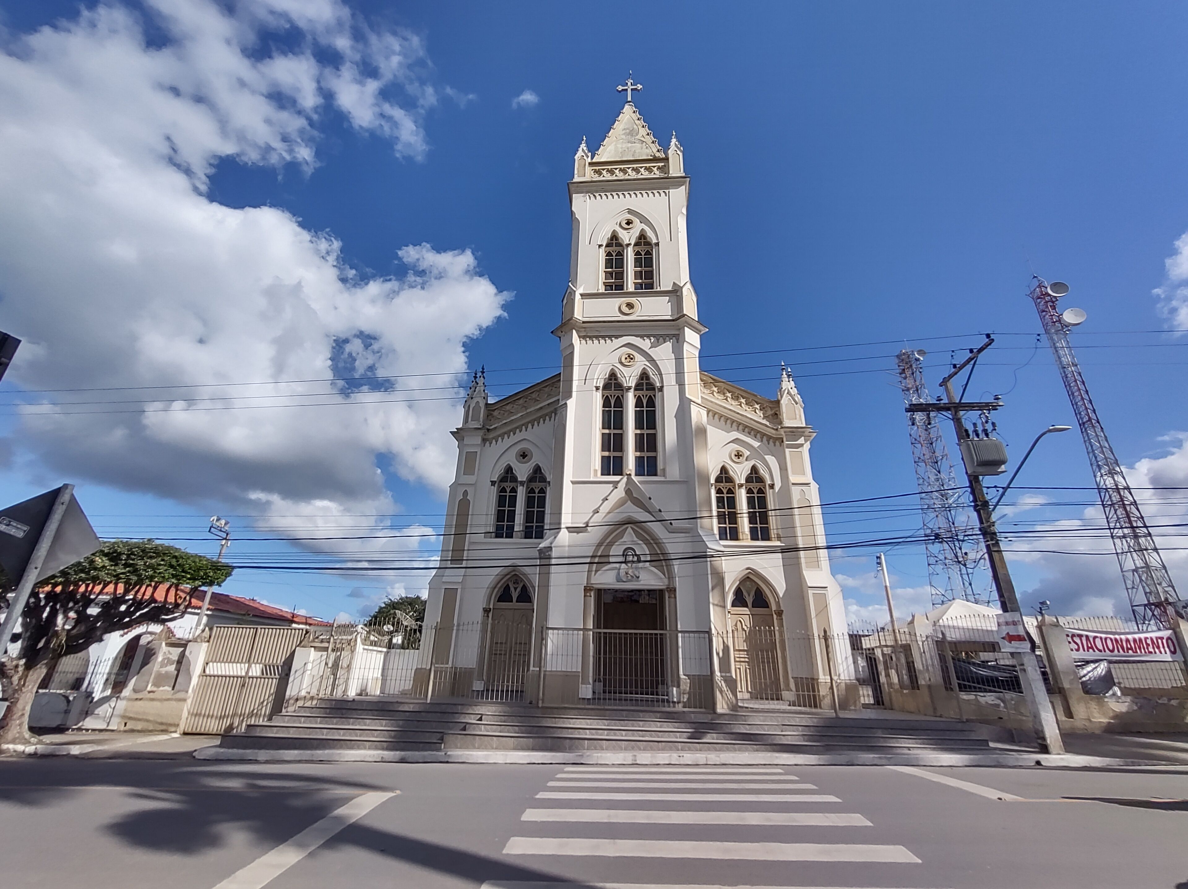A white church with a tall bell tower and arched windows.