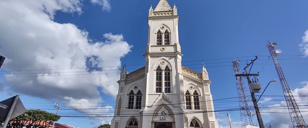 A white church with a tall bell tower and arched windows.