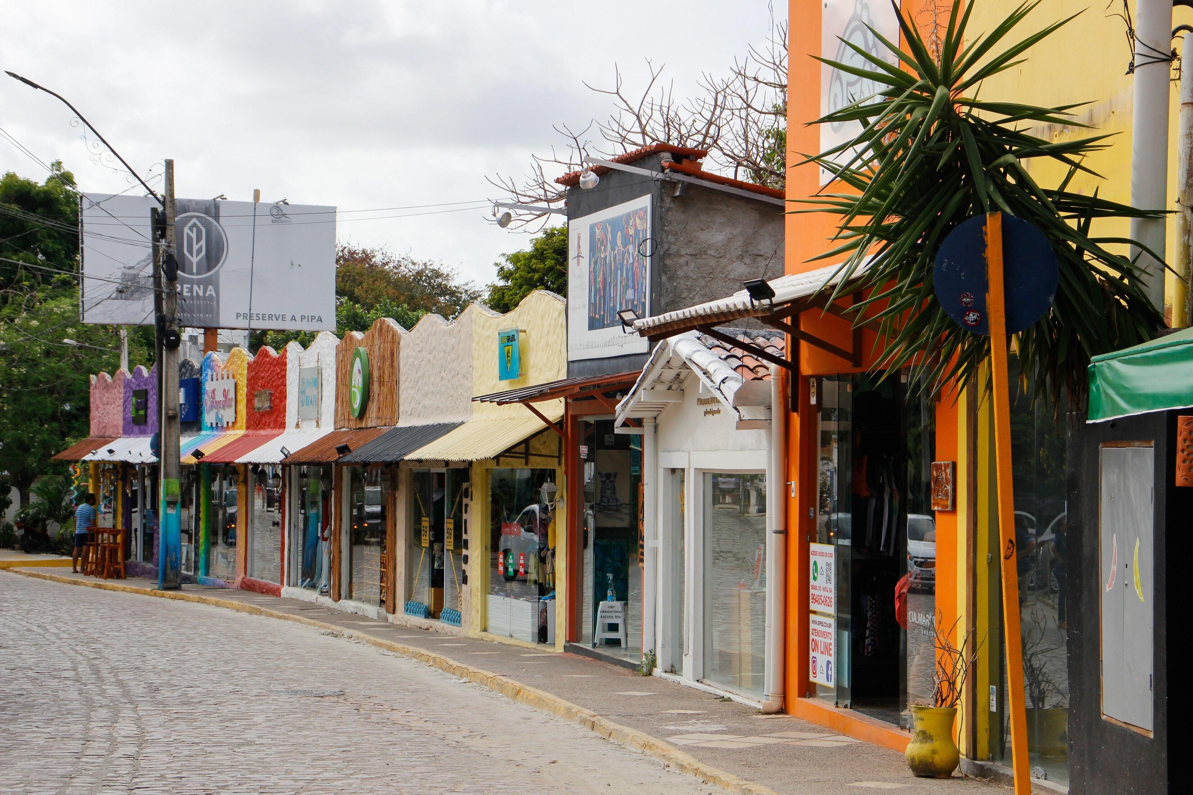 A colorful street with various shops and a sign that reads "PRESERVE A PIPA".