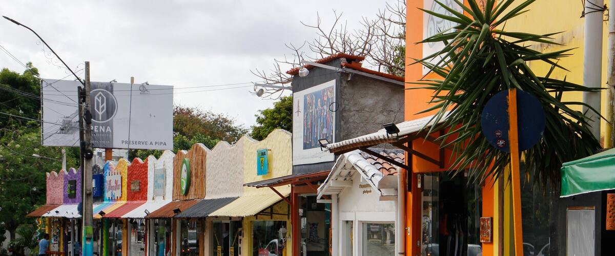 A colorful street with various shops and a sign that reads "PRESERVE A PIPA".