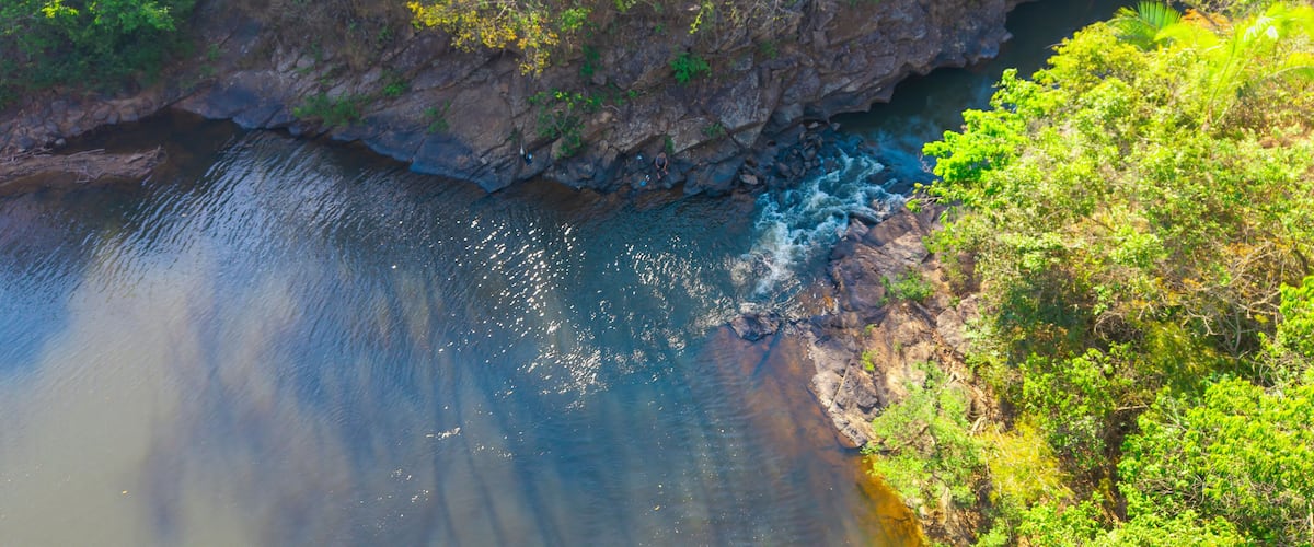 A river flowing through a rocky gorge with dense green foliage on the banks.