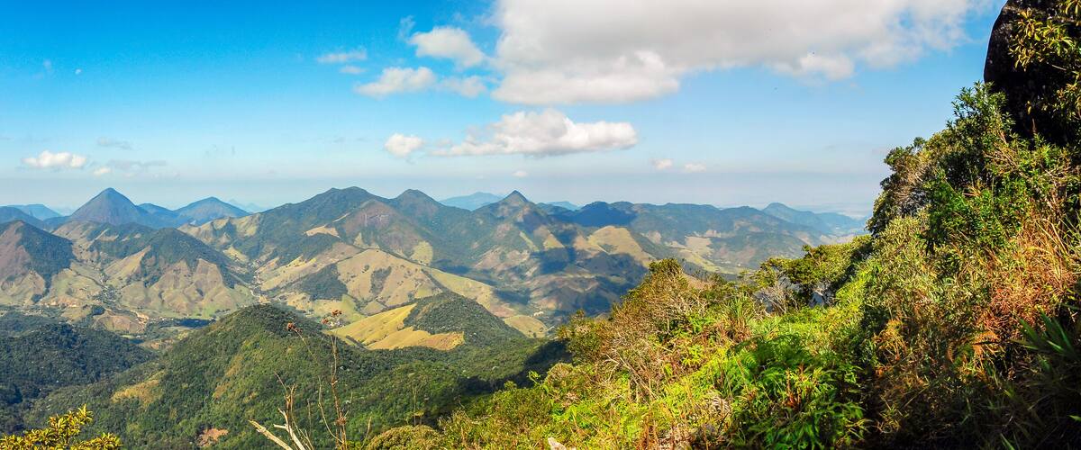 A mountainous landscape with dense forests and clear blue skies.