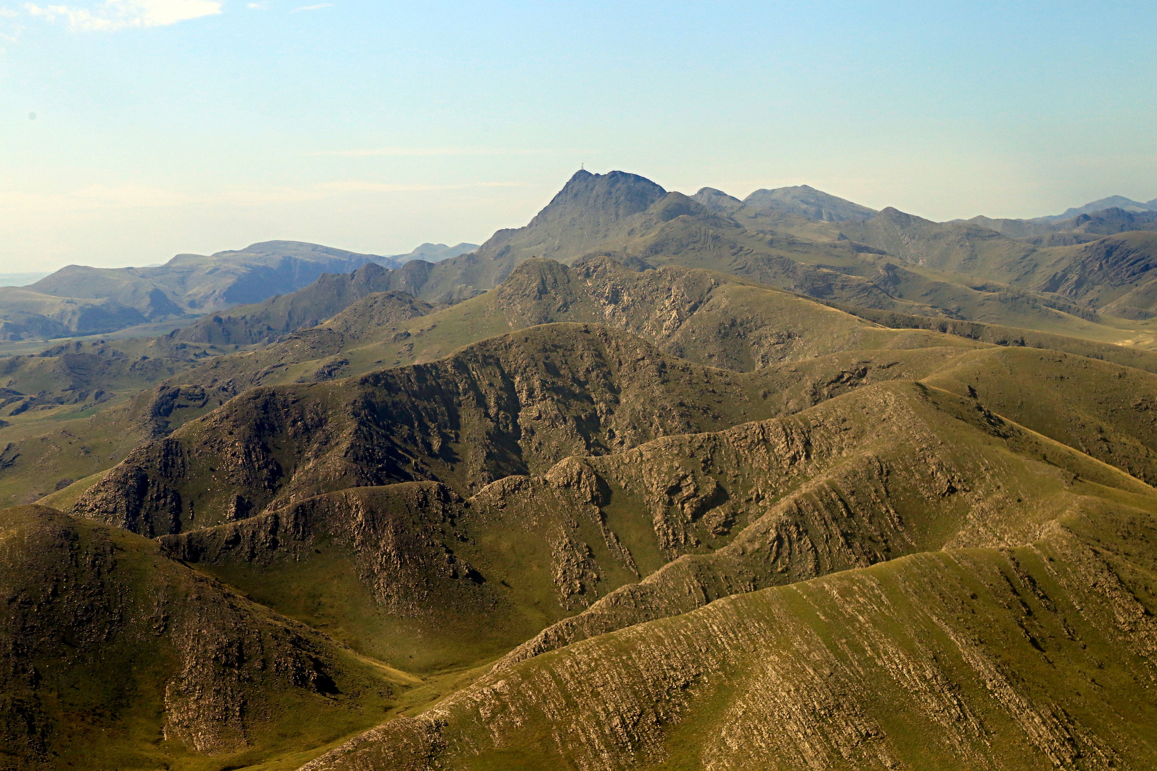 A rugged mountainous landscape with a prominent peak in the center.