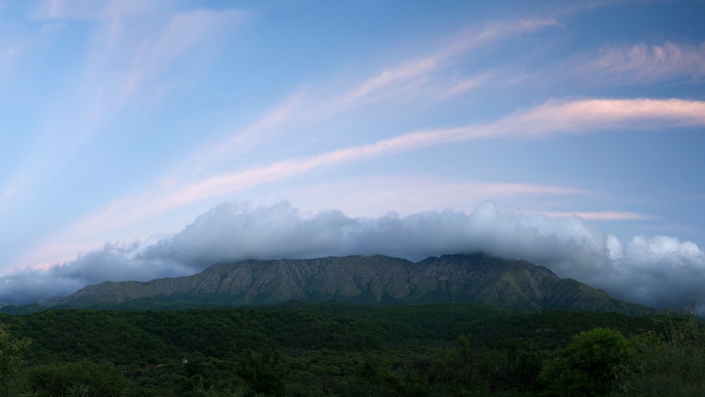 Magical view of popular landmark Uritorco hill, valley and green forest at sunset, in Capilla del Monte, Cordoba, Argentina.