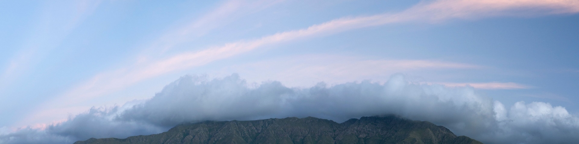 Magical view of popular landmark Uritorco hill, valley and green forest at sunset, in Capilla del Monte, Cordoba, Argentina.