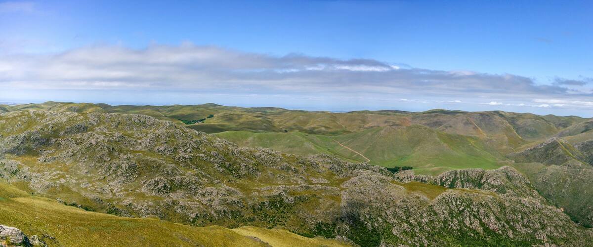 A mountainous landscape with rolling hills and a clear sky.