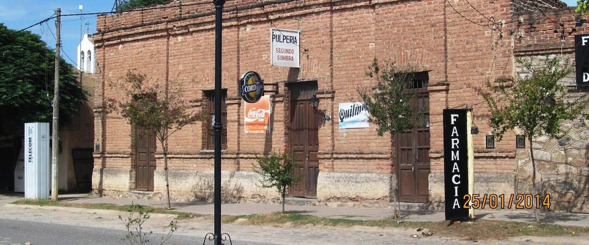 A historic brick building with signs for 'Pulperia Segundo Sombra' and 'Farmacia'.