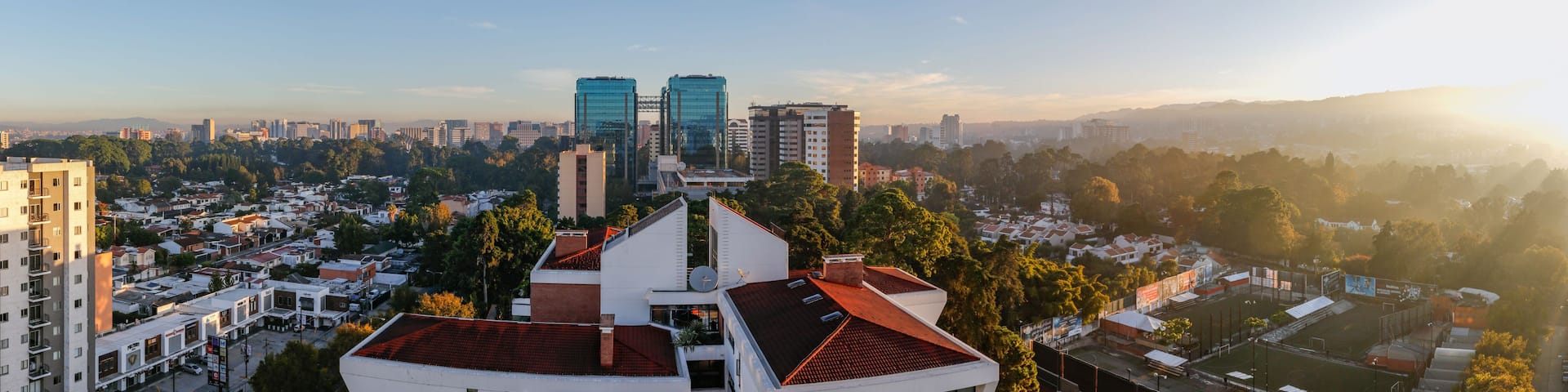 A cityscape with modern buildings, a mix of residential and commercial areas, and a clear sky.