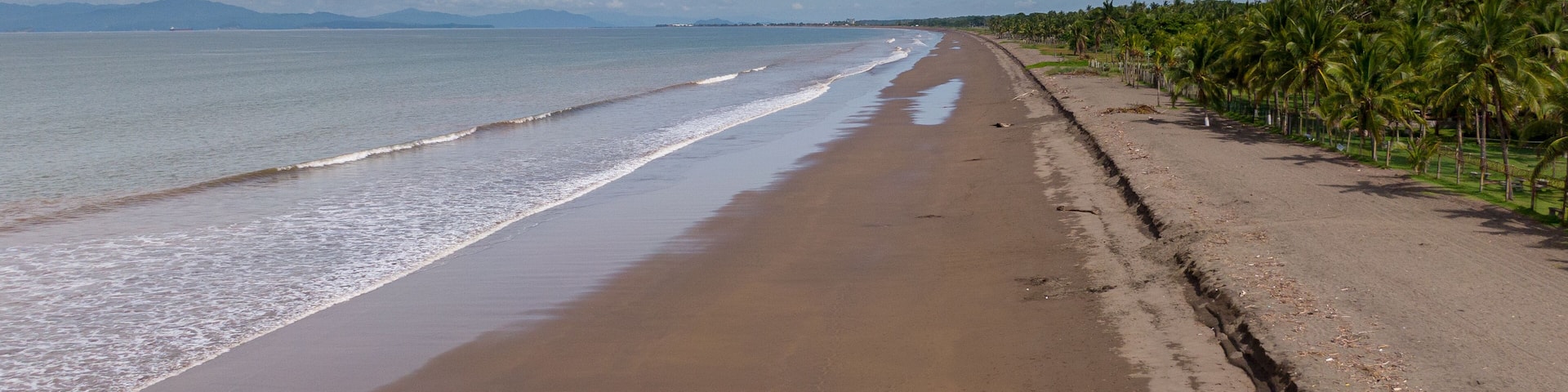 Beautiful aerial view of a empty beach due to the quarantine for Covid19, with a police car in Costa Rica