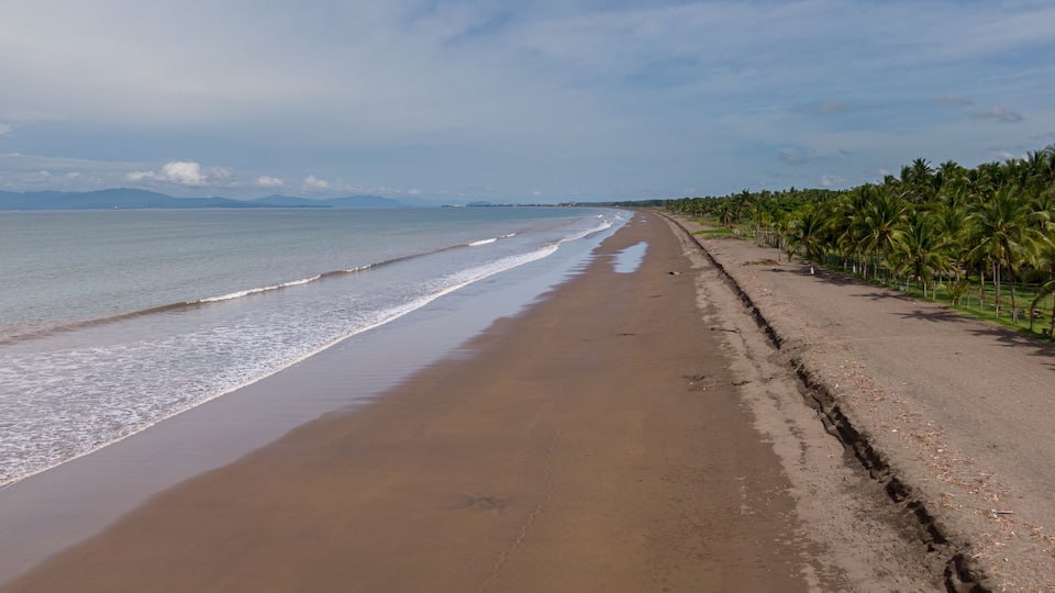 Beautiful aerial view of a empty beach due to the quarantine for Covid19, with a police car in Costa Rica