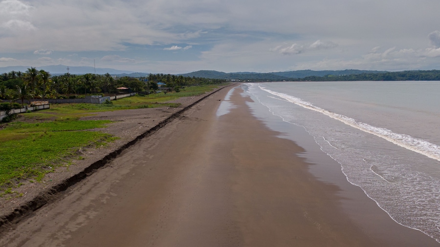 Beautiful aerial view of a empty beach due to the quarantine for Covid19, with a police car in Costa Rica