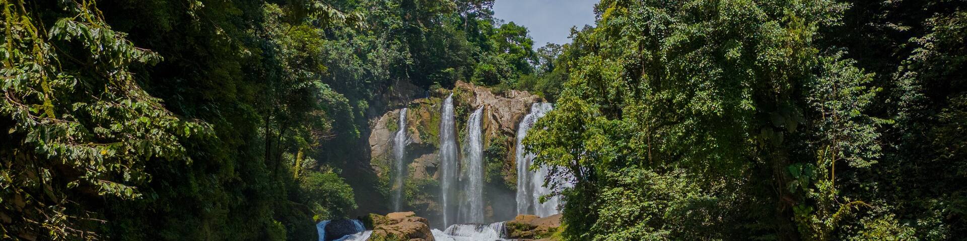 Nauyaca Waterfall in Perez Zeledon, San Jose, Costa Rica. Aerial drone footage of beautiful multi-stage waterfall. With Tourists swimming and enjoying the waterfall.