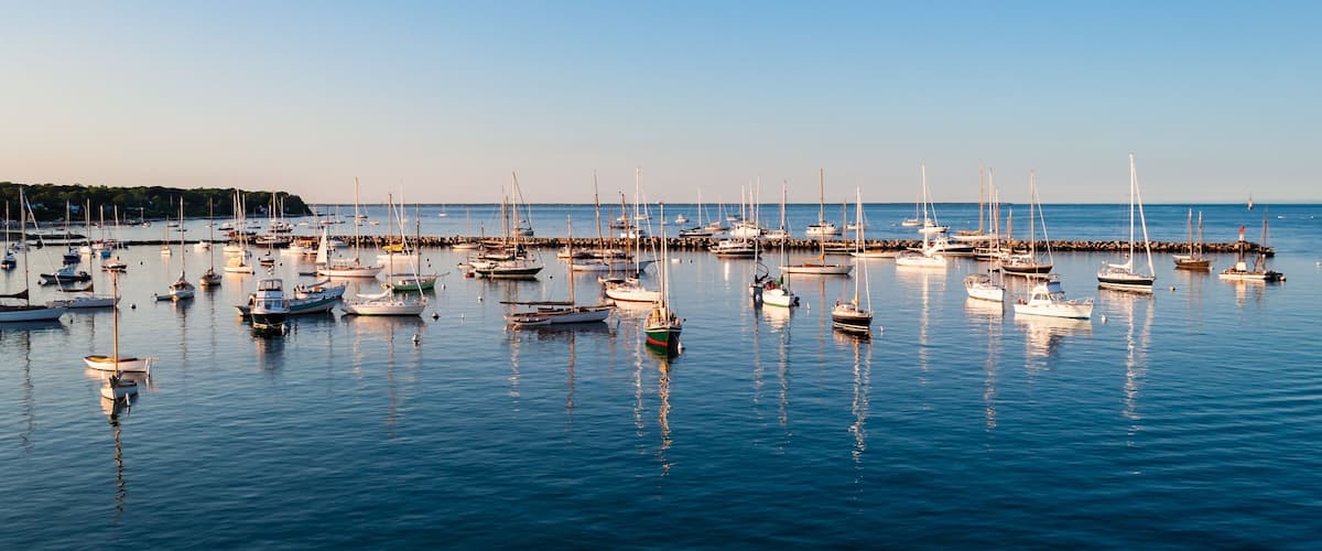 A marina with numerous sailboats docked at the pier.