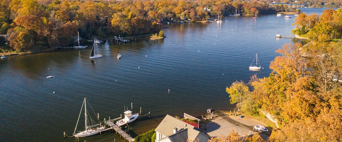 Aerial view of colorful sailboat moorings, docks, and bright golden foliage on Weems Creek, in historic downtown Annapolis Maryland on a fall day