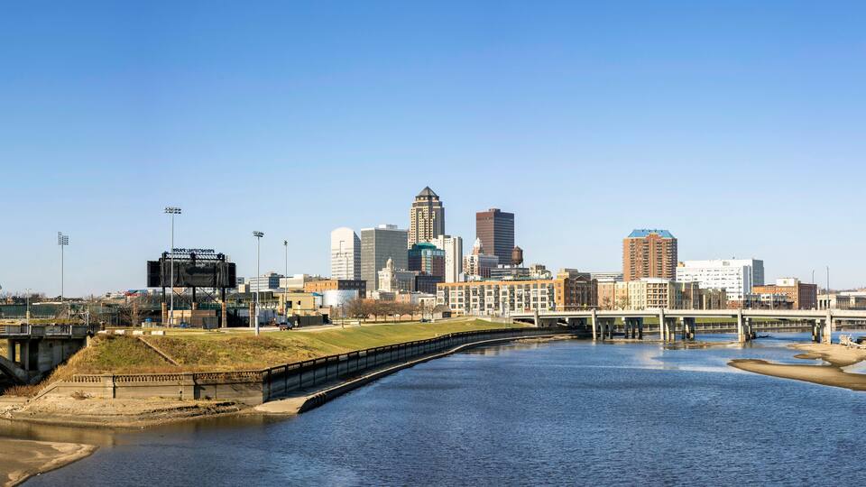 A river with a bridge, a city skyline, and a stadium.