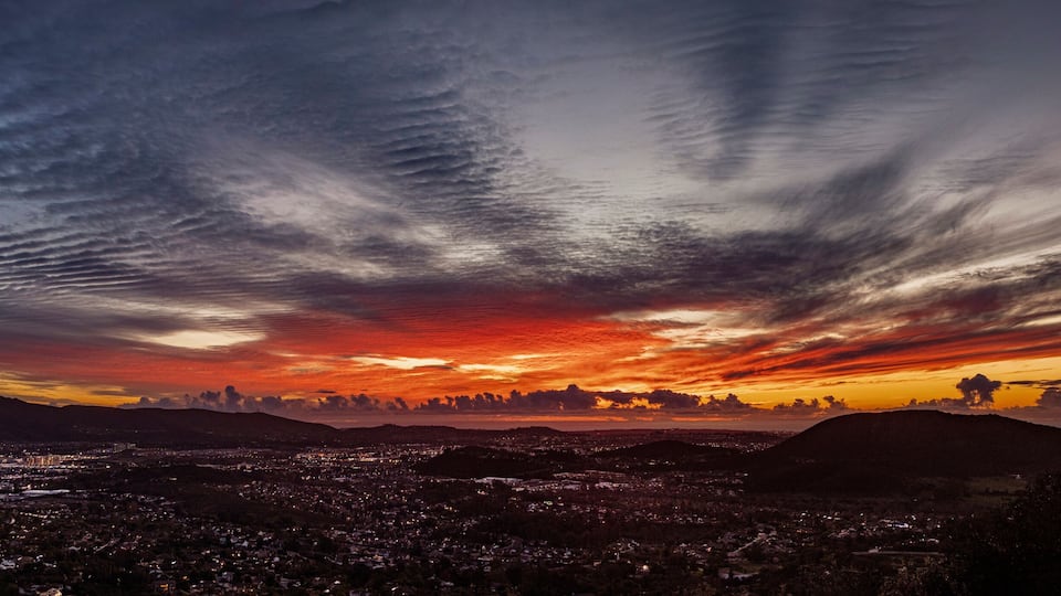 A beautiful sunset from a hill overlooking a city with storm clouds. The view is from Escondido Ca looking west toward San Marcos,Carlsbad and Oceanside Ca
