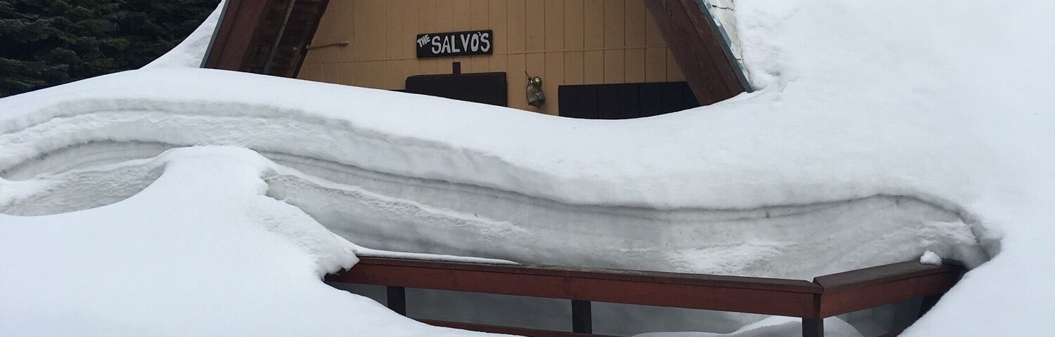 Una cabaña de madera con techo cubierto de nieve, con la inscripción '20300 The Salvos'.