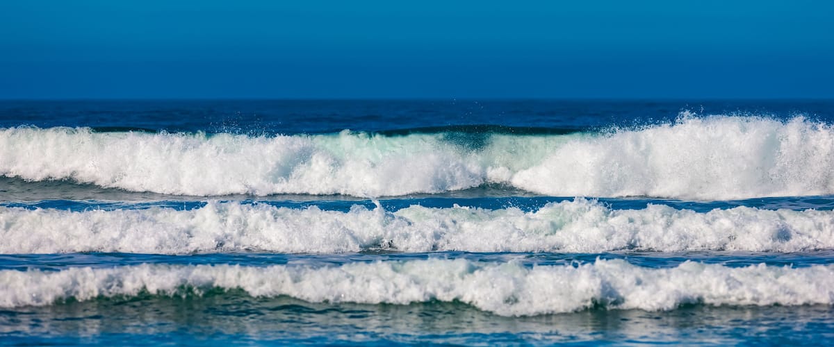 Ocean waves with a clear blue sky.