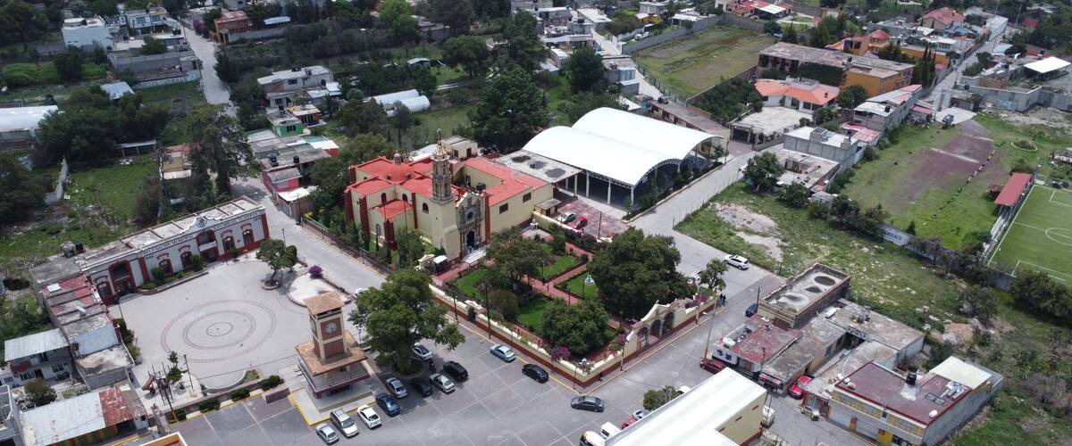 An aerial view of a town with a prominent church, a hospital, and a large white building.