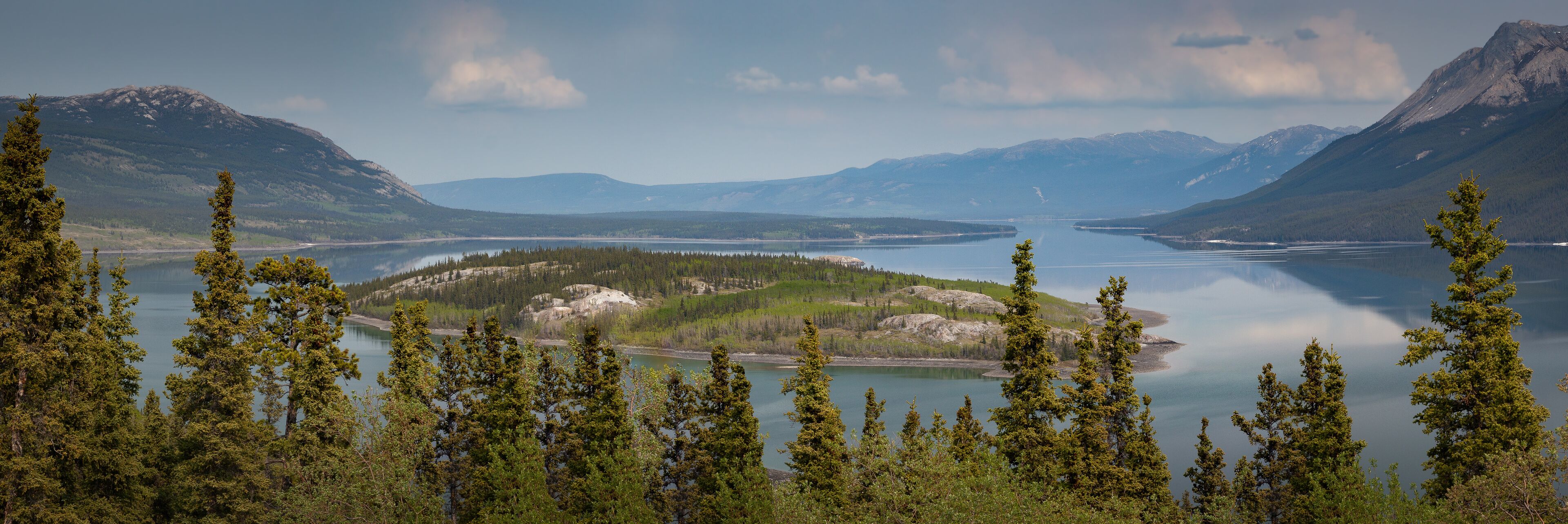A lake surrounded by mountains and dense forests.