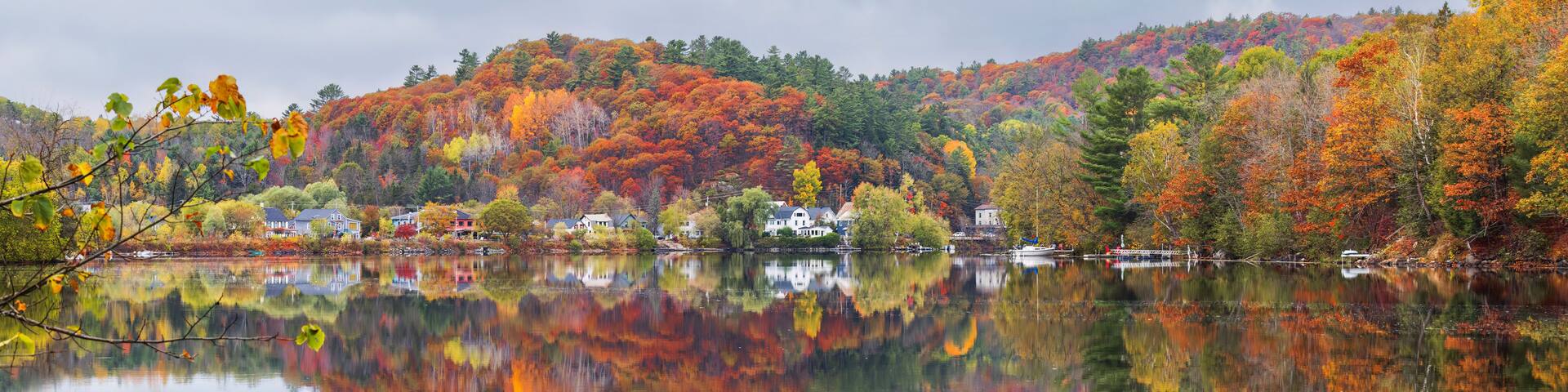 Fall colours along the Gatineau river reflected in the water, Wakefield, Quebec, Canada