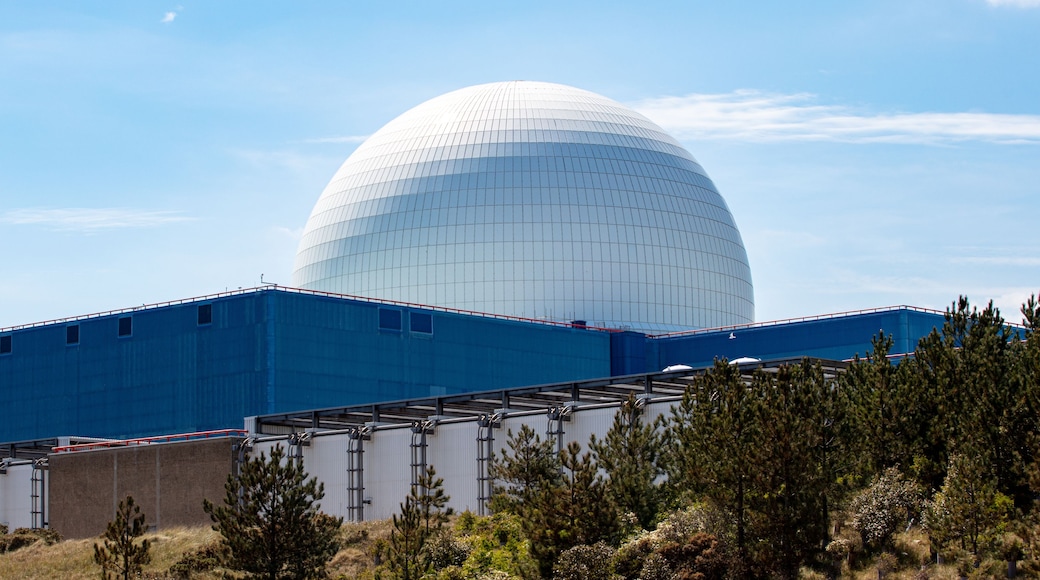 A large white dome structure with a blue building in the foreground.