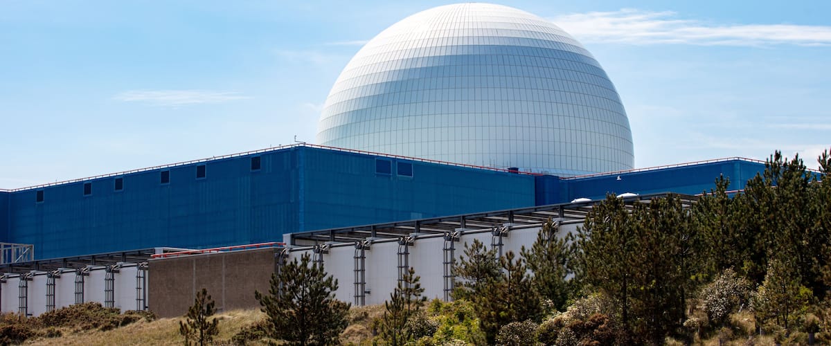 Een grote witte koepelstructuur met een blauw gebouw op de voorgrond.