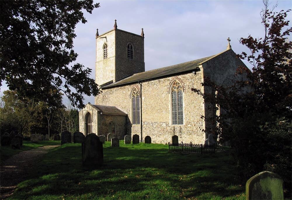 A stone church with a bell tower and a graveyard.