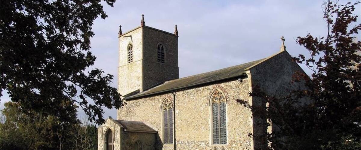 A stone church with a bell tower and a graveyard.