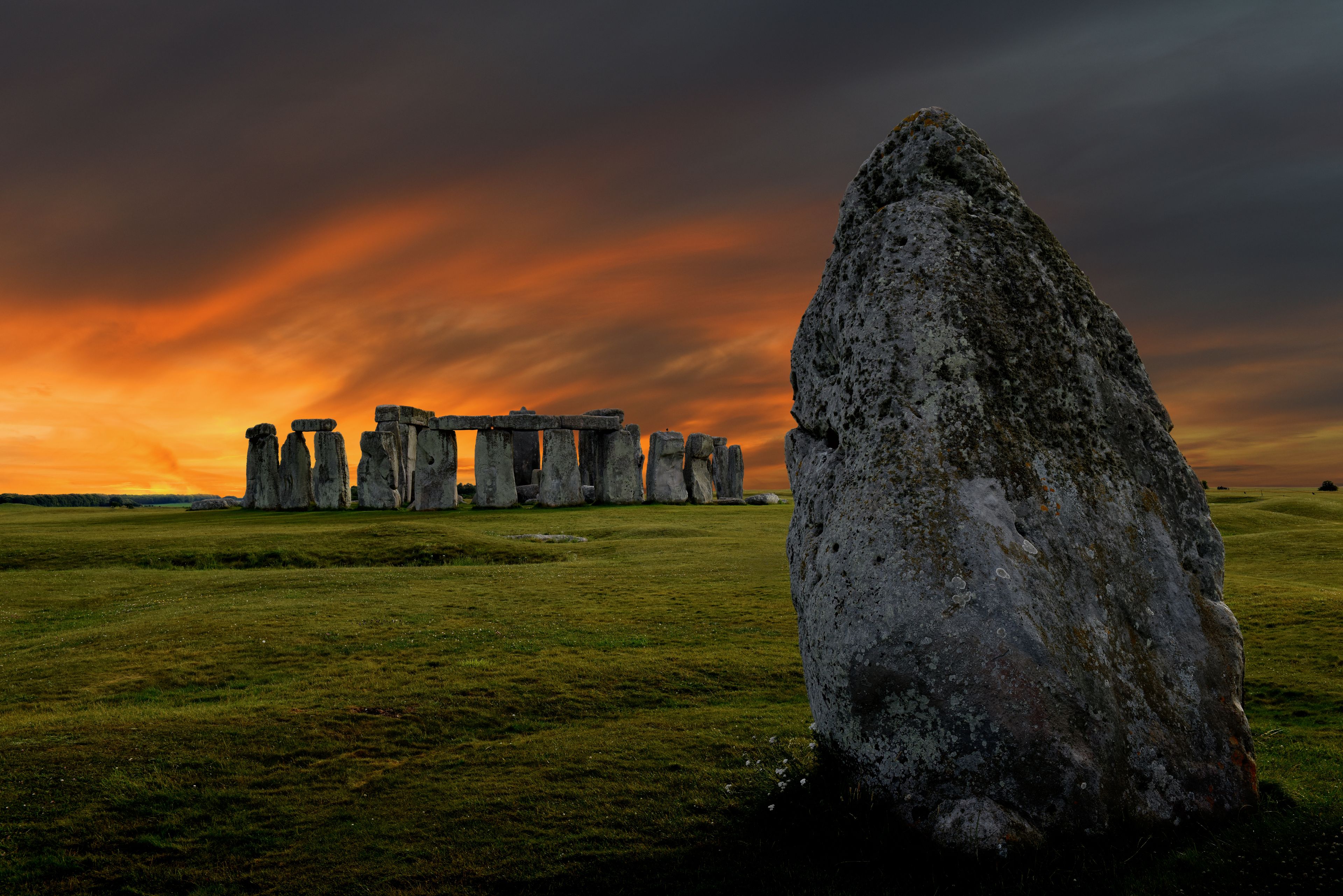 Stonehenge, a prehistoric monument with standing stones, set against a dramatic sunset sky.