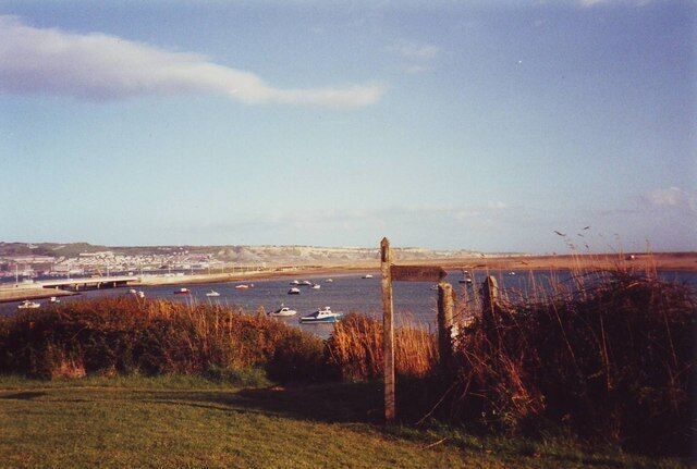 Sign for the Dorset Coastal Path at Chesil Beach Holiday Village In the background is Portland Isle.