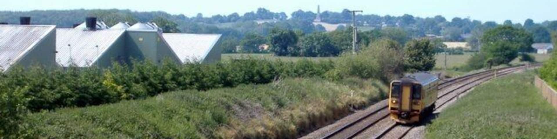 Nantwich-Whitchurch railway, near Wrenbury. Photo taken from Pinsley Green Road bridge next to Smeatonwood Farm, looking south-west towards Whitchurch. The popularity of public transport is shown by the huge size of the local train. In the distance (2.7 km away on the ridge) is the Combermere Monument, celebrating the victories at Salamanca and Bhurtpore of Field Marshal Sir Stapleton Cotton, 1st Baron Combermere, of nearby Combermere Abbey.