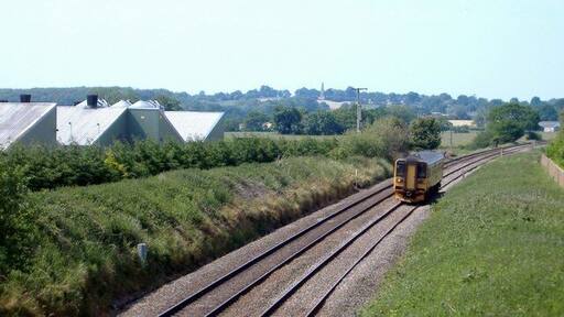 Nantwich-Whitchurch railway, near Wrenbury. Photo taken from Pinsley Green Road bridge next to Smeatonwood Farm, looking south-west towards Whitchurch. The popularity of public transport is shown by the huge size of the local train. In the distance (2.7 km away on the ridge) is the Combermere Monument, celebrating the victories at Salamanca and Bhurtpore of Field Marshal Sir Stapleton Cotton, 1st Baron Combermere, of nearby Combermere Abbey.