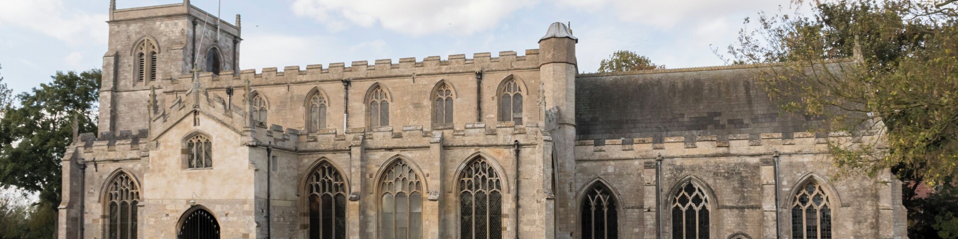 Wrangle is mentioned in the Domesday Book of 1086 when it was spelt Weranghe but by 15th century it had been changed to Wranghill. There was almost certainly a Saxon church on the site in 1086 and the present church is based on the beautiful cathedrals of 12th century France. It is a Marshland church, ie predominantly perpendicular, but there are older parts as well. The arch on the east side of the tower and the south door are believed to be 1190s. The church was given with much land to Waltham Abbey, Essex in the time of Henry II (1154-89) – the priests of that period being supplied by Waltham Abbey. In the glass of the east window was once an inscription “Thomas de Wyversty, abbas de Waltham me fieri fecit” (the dates of his abbacy of Waltham are 1345-71) The church was rebuilt in the 1400s. St Mary & St Nicholas is built in late Norman and Early English style with later additions. It has a fine pulpit of the Elizabethan period and a tower with six bells. Wrangle was an important place in the 13th and 14th centuries when the church was built. In 1359 King Edward III needed a navy to invade France and Wrangle was asked to help. It sent one ship and eight men (Liverpool only sent five men). Although now a mile from the sea, in medieval times Wrangle Church sat next to a creek up which boats sailed from the Wash. The river has long since been silted up but the outline of the banks can still be seen in a field next to the church.