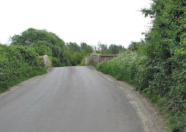 The old bridge over the River Glaven. Approaching Wiveton Bridge > 841511 spanning the River Glaven, located a short distance south of St Mary's church > 840845 - it has a single arch and dates from the 15th century. A chapel once used to stand close by the bridge and it is believed that the brick buttress platform on one corner of the bridge might be associated with it > 841506. No trace remains of the chapel.