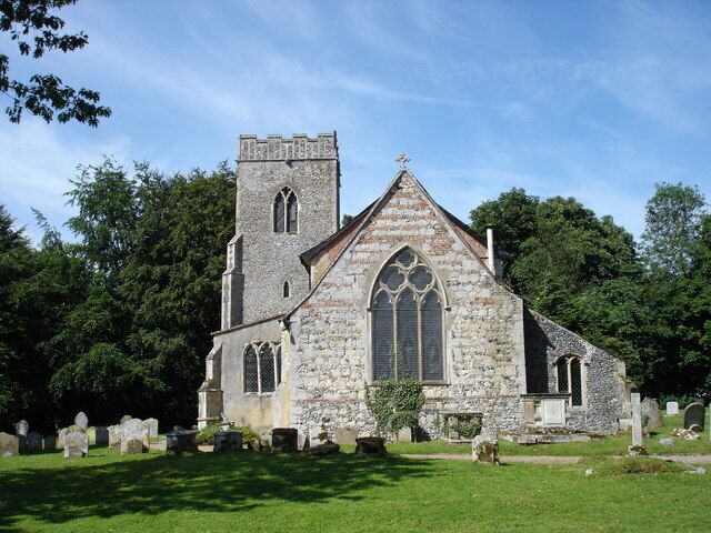 A stone church with a bell tower and large arched windows.