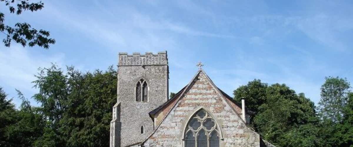 A stone church with a bell tower and large arched windows.